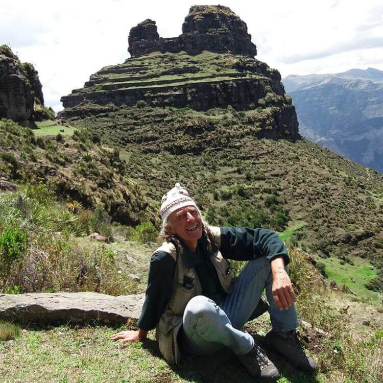 mountain A grassy mountain top behind a man during a Condor Canyon tour in Cusco