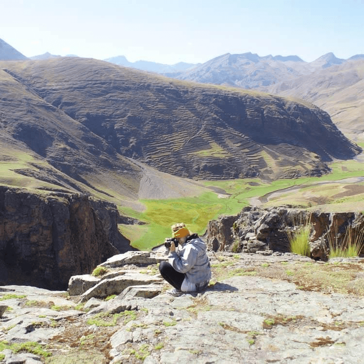A person taking a photo with Ananiso Canyon in background.