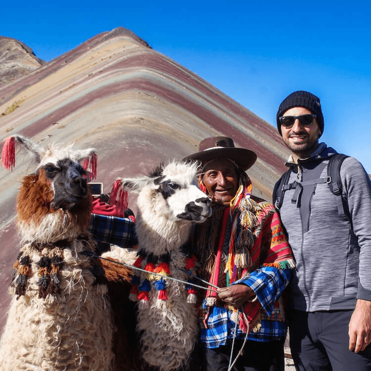 A picture of a tourist, a local, and a llama at Rainbow Mountain.