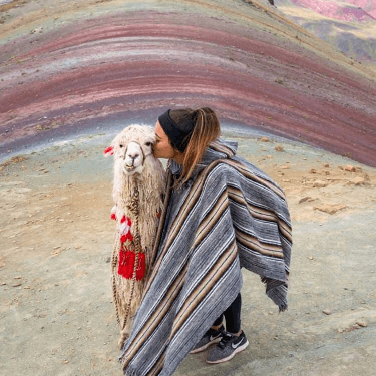  A tourist posing with a llama at Rainbow Mountain.