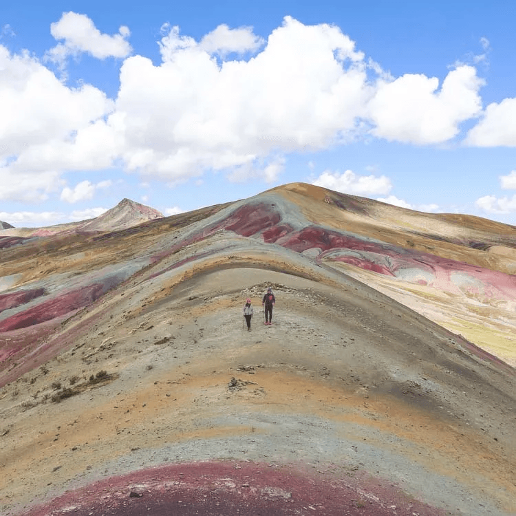 rainbow mountain1 Two people hiking up Rainbow Mountain.