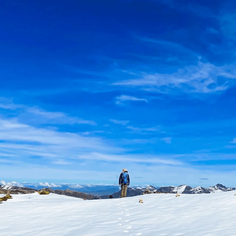 A person at the top of a snowy mountain.
