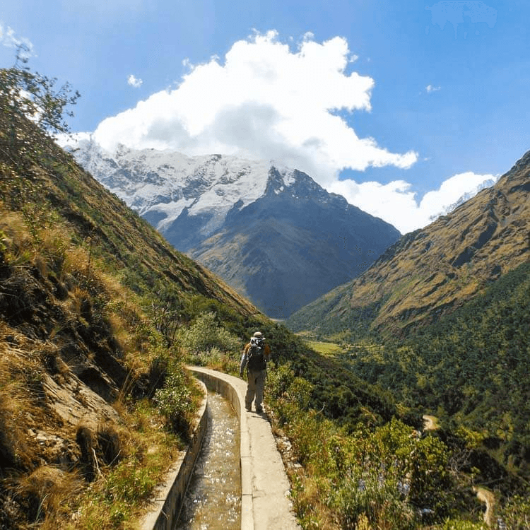 A person trekking through a mountain valley.