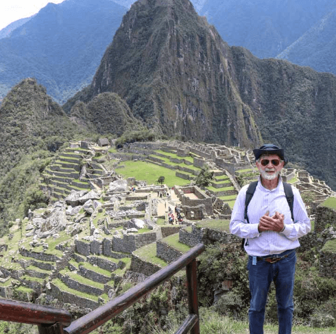 A panoramic view of Machu Picchu’s stone ruins surrounded by green mountains and mist.