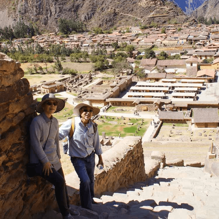 people houses rock mountain People posing for a picture in front of a valley with houses