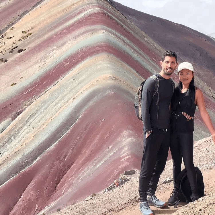 Two people posing in front of the Rainbow Mountain 