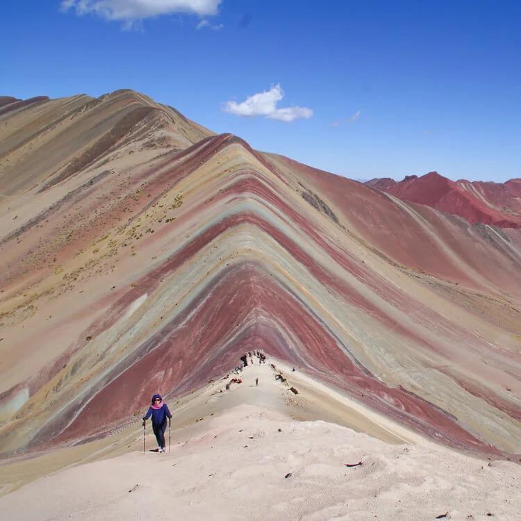 a person trekking up the Puno Rainbow Mountain