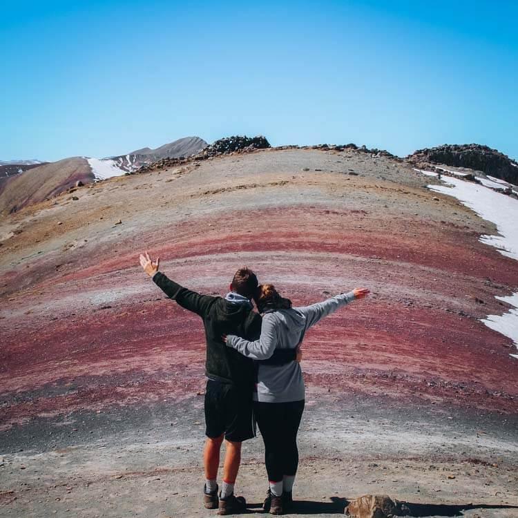 a couple posing in front of the Rainbow Mountain