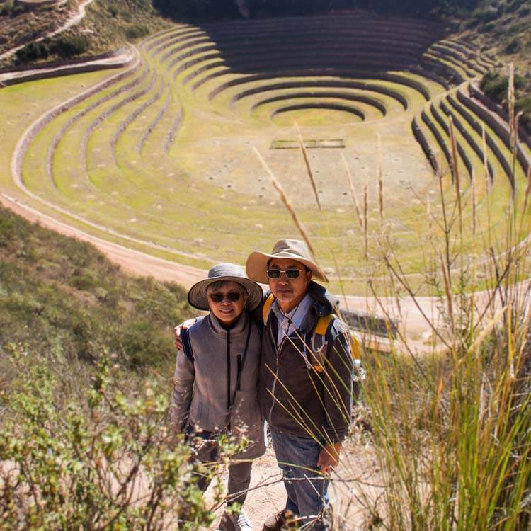 a tourist couple posing at the stairs of the Sacred Valley