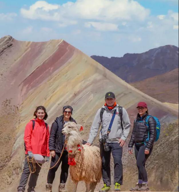 A group of people standing in front of the Rainbow Mountain