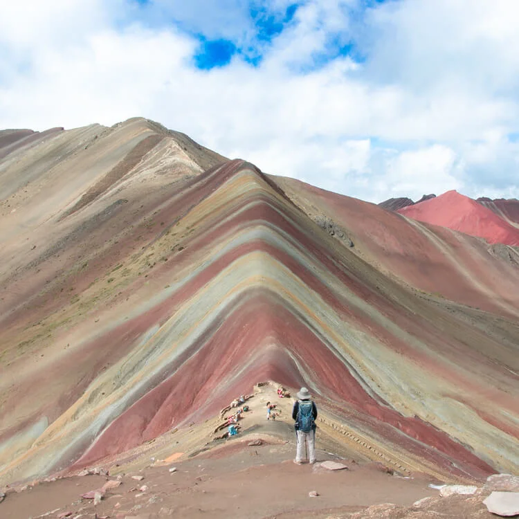 a person standing between the Rainbow Mountain