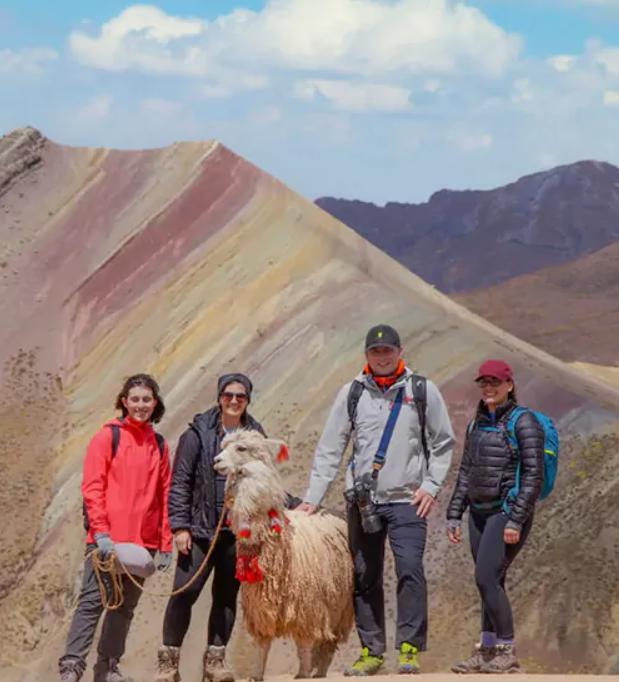 A team of people standing together next to the rainbow mountain