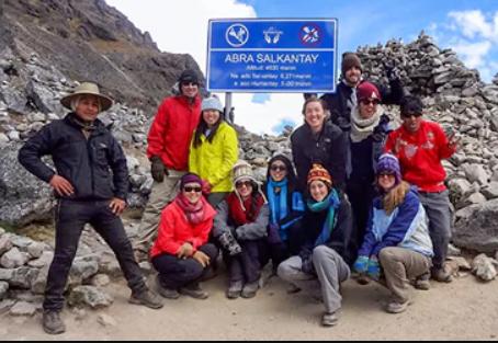 A team of people standing together near the rainbow mountain