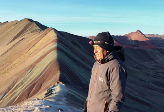 a person standing in the middle of Vinicunca Rainbow Mountain