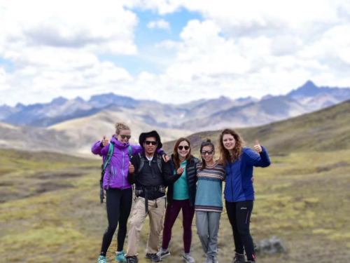 A small group of smiling travelers posing with a local guide.