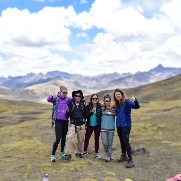 A small group of smiling travelers posing with a local guide.