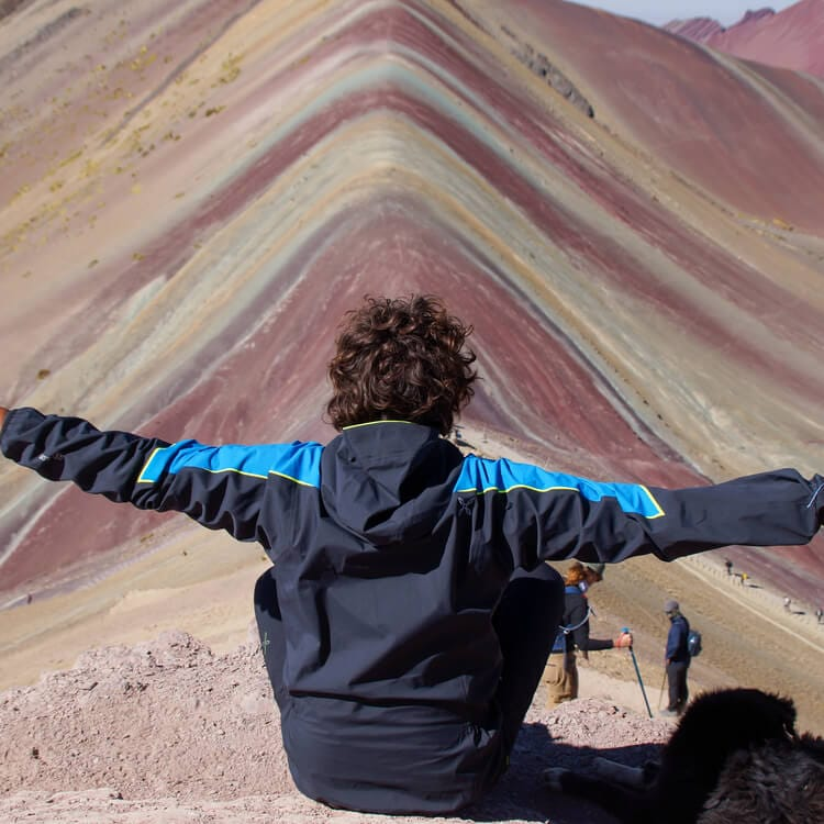 a person posing in between Rainbow Mountains