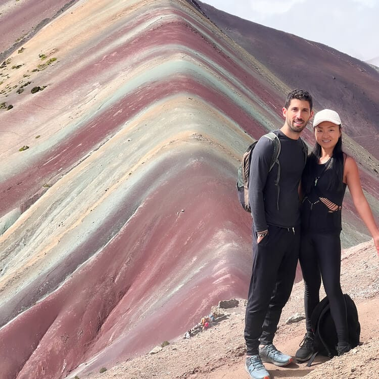 Couple posing in front of Rainbow Mountain during a summer visit