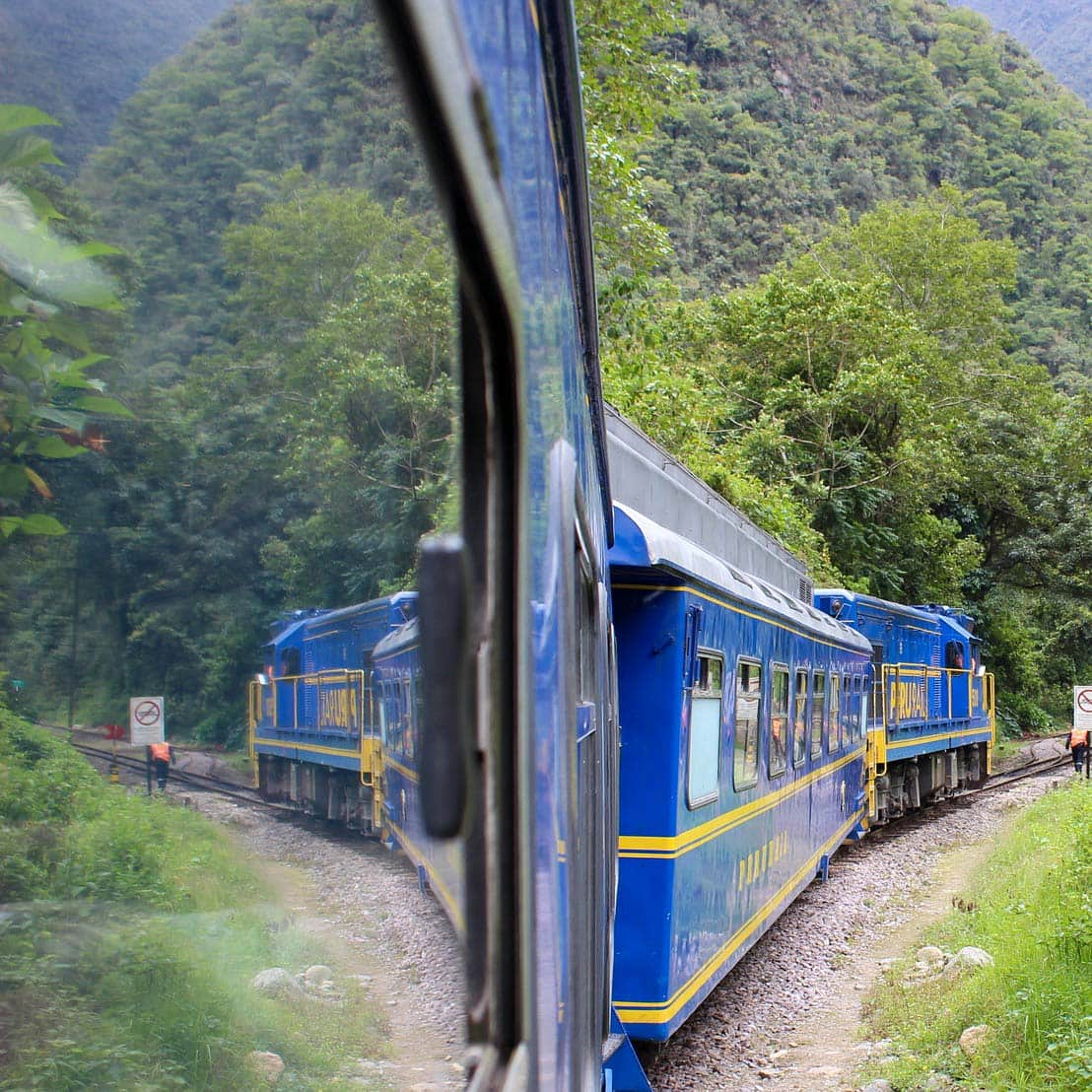 a blue train going through Machu Picchu on tour