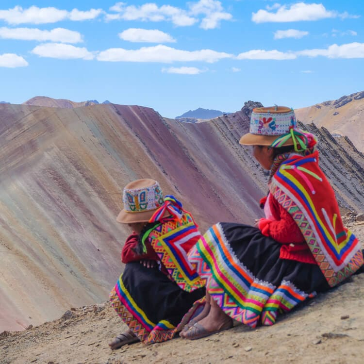 close-up of local tour guides sitting between the Rainbow Mountains